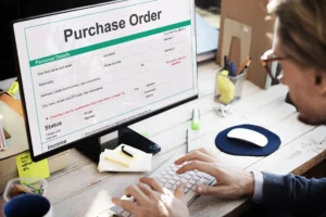 Person typing at a desk while viewing an order management system - Order Management Workflow