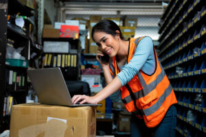 Smiling woman in orange safety vest - Cin7 Alternatives